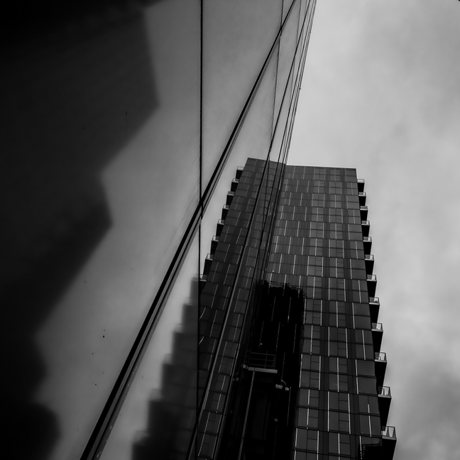 A black and white photo exterior, from ground looking up, of a London office block.