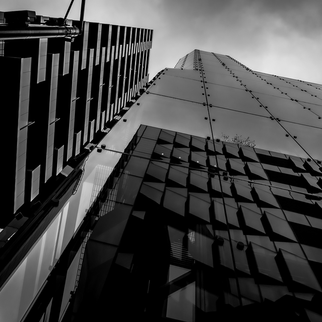 A black and white photo exterior, from ground looking up, of a London office block.