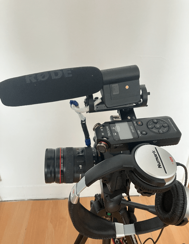 dslr camera, on tripod, rode shot-gun mic, audio recorder and headphones all attached together on tripod. 